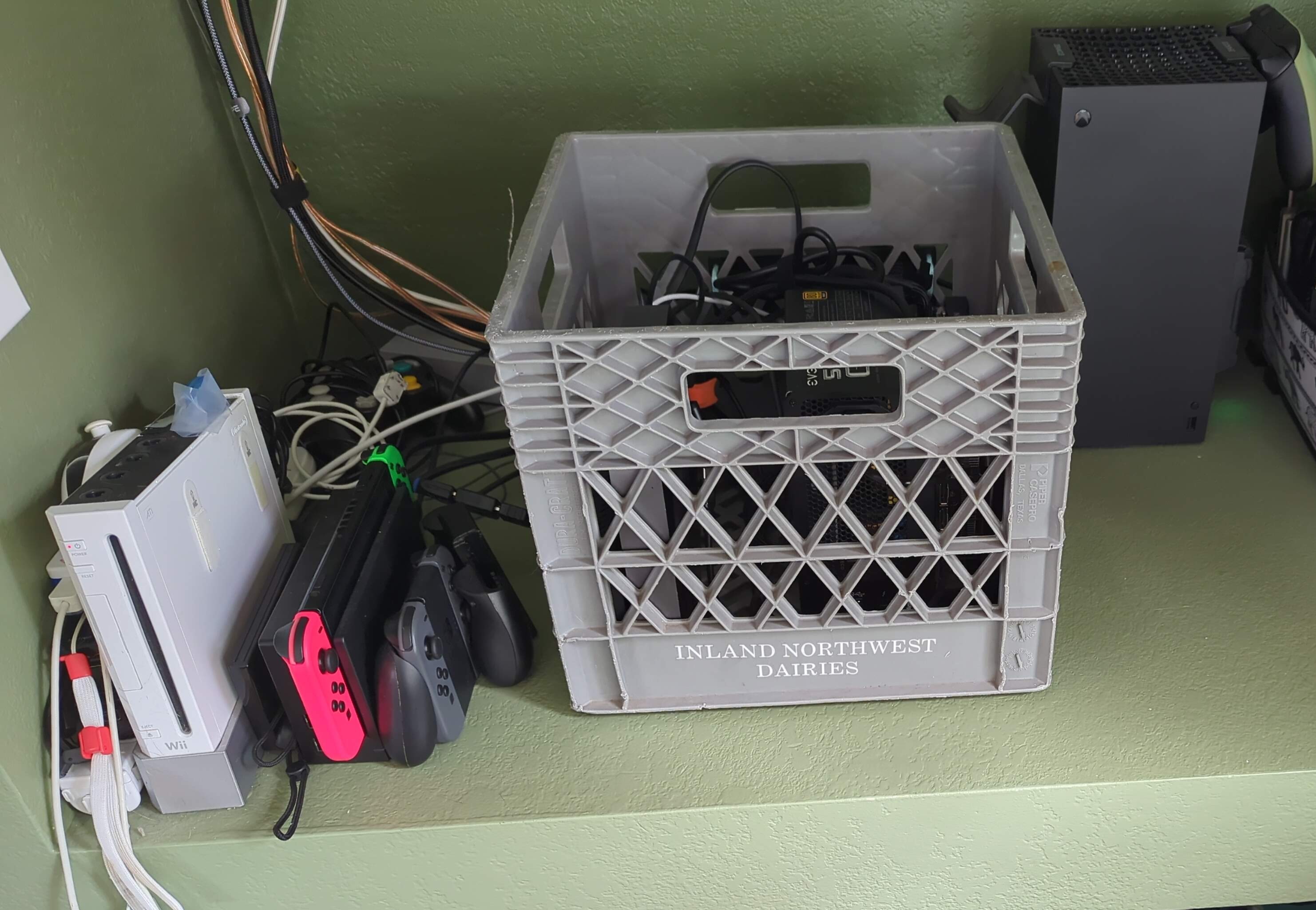 A computer in a milk crate on a shelf